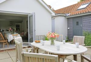 a table with a vase of flowers on a patio at 4 Bed in Walberswick oc-ltm in Walberswick