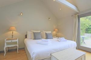 a bedroom with a white bed with two lamps and a window at 4 Bed in Walberswick oc-ltm in Walberswick