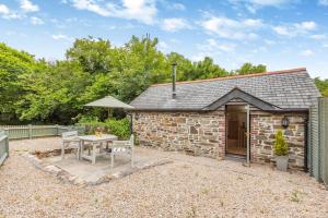 a stone cottage with a table and an umbrella at 1 Bed in Bodmin oc-p00438 in Bodmin