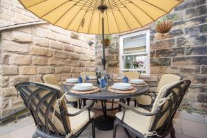 a table with chairs and an umbrella on a patio at 3 Bed in Crich oc-dcivyd in Crich