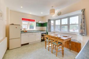 a kitchen with a table and a refrigerator at 4 Bed in Southwold oc-spn in Reydon