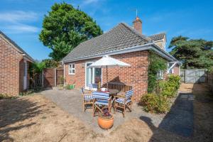 a patio with a table and chairs and an umbrella at 4 Bed in Southwold oc-spn in Reydon