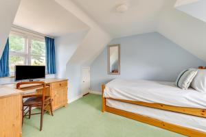 a bedroom with a bed and a desk with a computer at 4 Bed in Southwold oc-spn in Reydon