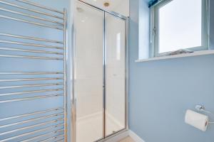 a glass shower door in a bathroom with a window at 6 Bed in Knodishall oc-bil in Aldringham +13 photos
