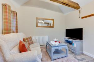 a living room with a white couch and a tv at 1 Bed in Great Waldingfield oc-ac1 in Waldingfield