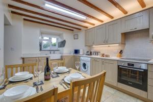 a kitchen with a wooden table and chairs and a kitchen with a table and chairs at 2 Bed in Barmouth oc-wah699 in Talybont +12 photos