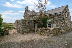 an old stone house with a stone wall at 2 Bed in Barmouth oc-wah699 in Talybont