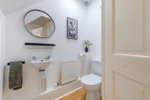a white bathroom with a toilet and a mirror at 2 Bed in Alnwick oc-e33447 in Embleton +19 photos