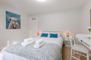a white bedroom with a bed with towels on it at 2 Bed in Alnwick oc-e33447 in Embleton