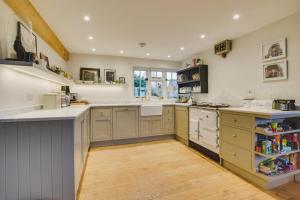 a large kitchen with white counters and a wooden floor at 3 Bed in Walberswick oc-spinn in Walberswick +17 photos