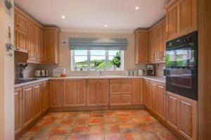 a large kitchen with wooden cabinets and a window at 3 Bed in Trimingham oc-2290 in Trimingham