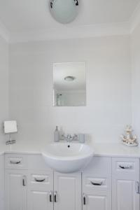 a white bathroom with a sink and a mirror at 3 Bed in Trimingham oc-2290 in Trimingham +16 photos