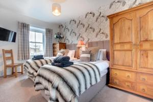 a bedroom with two beds and a wooden cabinet at 3 Bed in Hawes oc-ds1009 in Hawes
