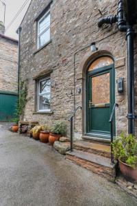 a brick house with a green door and potted plants at 3 Bed in Hawes oc-ds1009 in Hawes