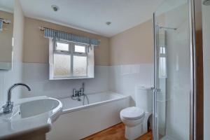 a bathroom with a tub and a toilet and a sink at 2 Bed in Bodham oc-1303 in Bodham +11 photos