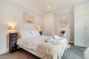 a bedroom with a white bed and a mirror at 4 Bed in Southwold oc-l29092 in Southwold
