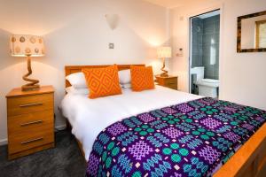 a bedroom with a large bed and a night stand with a lamp at 3 Bed in Pwllheli oc-hillvi in Llanbedrog
