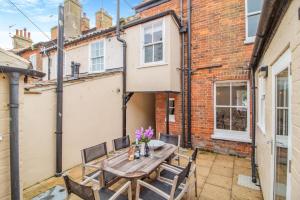 a patio with a wooden table and chairs at 4 Bed in Southwold oc-l29092 in Southwold