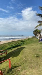 a view of a beach with palm trees and the ocean at Geminado em Barra Velha SC in Barra Velha
