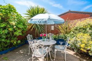 a table and chairs with an umbrella on a patio at 2 Bed in Sheringham oc-2029 in Sheringham