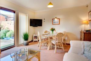 a living room with a table and chairs and a tv at 2 Bed in Sheringham oc-2029 in Sheringham