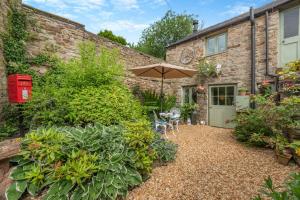 a garden with an umbrella and chairs and a building at 1 Bed in Reeth oc-t29540 in Reeth
