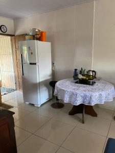 a kitchen with a table and a white refrigerator at Geminado em Barra Velha SC in Barra Velha +14 photos