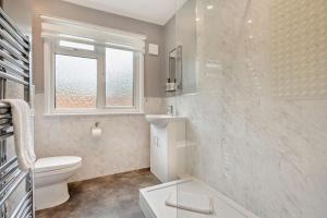 a bathroom with a toilet and a sink and a window at 3 Bed in Acton oc-c28929 in Waldingfield +16 photos