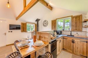 a kitchen with wooden cabinets and a table and chairs at 1 Bed in Okehampton oc-p29017 in Okehampton +15 photos