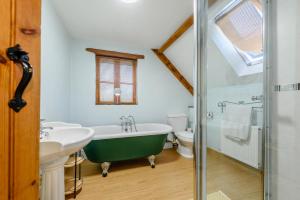 a bathroom with a green bath tub and a sink at 3 Bed in Manorbier oc-pw270a in Manorbier +28 photos