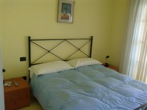 a bedroom with a large bed with blue sheets at Le Torri in Santa Marinella