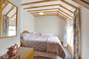 a bedroom with a bed and a window and a mirror at 3 Bed in Pwllheli oc-wag486 in Bryncroes