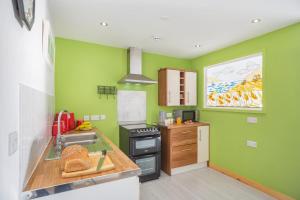 a green kitchen with a sink and a stove at 1 Bed in Nefyn oc-n28983 in Nefyn +5 photos