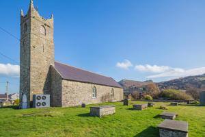 an old stone church with benches in a field at 1 Bed in Nefyn oc-n28983 in Nefyn