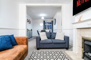 a living room with two couches and a fireplace at 2 Bedroom 5 Single Beds WiFi in Northampton