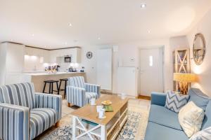 a living room with blue chairs and a table at 2 Bed in Bamburgh oc-gd0462 in Bamburgh