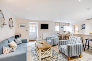 a living room with a blue couch and two chairs at 2 Bed in Bamburgh oc-gd0462 in Bamburgh