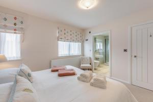 a bedroom with a large white bed with towels on it at 2 Bed in Bamburgh oc-gd0462 in Bamburgh