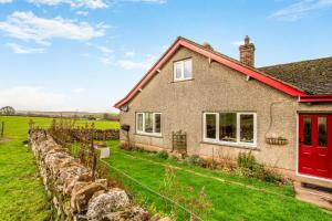 a house with a red door and a field at 2 Bed in Renwick oc-h34195 in Renwick
