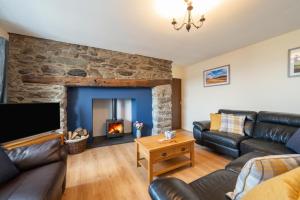 a living room with a couch and a fireplace at 3 Bed in Llanllechid oc-wag712 in Llanllechid