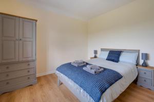 a bedroom with a bed and a dresser with towels on it at 3 Bed in Llanllechid oc-wag712 in Llanllechid