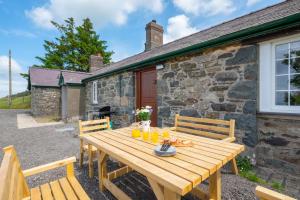 a wooden table in front of a stone cottage at 3 Bed in Llanllechid oc-wag712 in Llanllechid