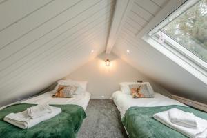 two beds in a attic room with a window at 2 Bed in Mouswald oc-b33444 in Mouswald