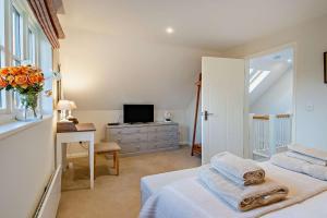 a bedroom with a bed and a desk and a television at 2 Bed in Wickhambrook oc-b30507 in Wickhambrook