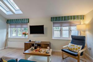 a living room with a chair and a tv at 2 Bed in Wickhambrook oc-b30507 in Wickhambrook