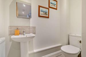 a white bathroom with a toilet and a sink at 3 Bed in Framlingham oc-f30353 in Framlingham +9 photos