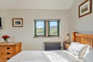 a bedroom with a bed and a desk and two windows at 1 Bed in Bracewell oc-l33325 in Bracewell