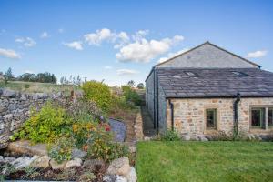 a stone house with a stone wall and a garden at 1 Bed in Bracewell oc-l33325 in Bracewell