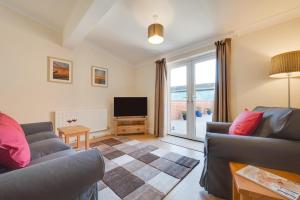 a living room with two couches and a television at 1 Bed in Chedgrave oc-2250 in Chedgrave