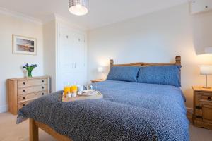 a bedroom with a blue bed with a tray of orange juice at 1 Bed in Chedgrave oc-2250 in Chedgrave